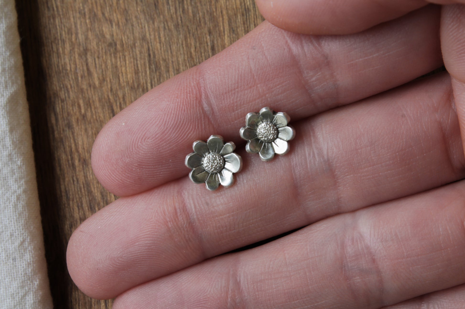daisy stud earrings, handmade sterling silver jewelry, floral stud earrings, nature-inspired earrings, eco-friendly jewelry, sustainable jewelry, handcrafted earrings, sterling silver studs, daisy earrings, artisan jewelry, flower stud earrings, recycled silver earrings, minimalist floral earrings, eco-conscious jewelry, boho earrings, nature jewelry, ethical jewelry, small floral studs, delicate earrings, dainty stud earrings