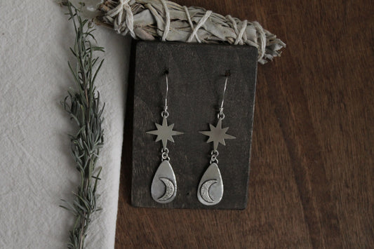 Handcrafted sterling silver earrings, celestial charm jewelry, sustainable sterling silver earrings, recycled silver jewelry, artisan-crafted earrings, unique silver statement earrings, celestial-themed earrings, sustainable fashion accessories, moon-inspired earrings, eco-friendly jewelry, handmade statement earrings, ethical silver jewelry, silver drop earrings, moon magic jewelry, celestial silver earrings, handmade in the USA, silver dangle earrings, silver jewelry for women, timeless silver earrings