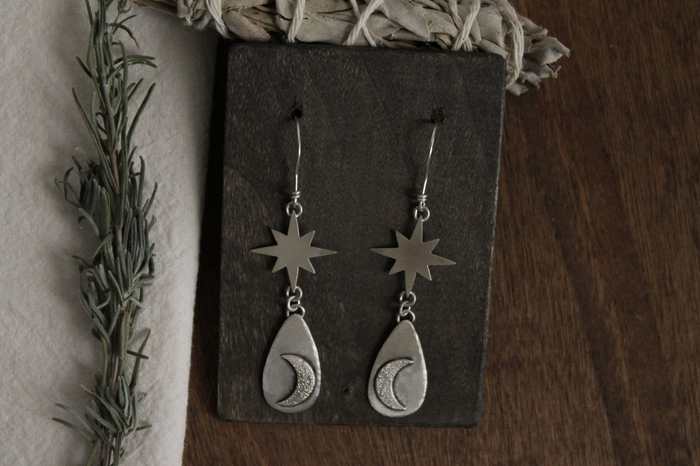 Handcrafted sterling silver earrings, celestial charm jewelry, sustainable sterling silver earrings, recycled silver jewelry, artisan-crafted earrings, unique silver statement earrings, celestial-themed earrings, sustainable fashion accessories, moon-inspired earrings, eco-friendly jewelry, handmade statement earrings, ethical silver jewelry, silver drop earrings, moon magic jewelry, celestial silver earrings, handmade in the USA, silver dangle earrings, silver jewelry for women, timeless silver earrings