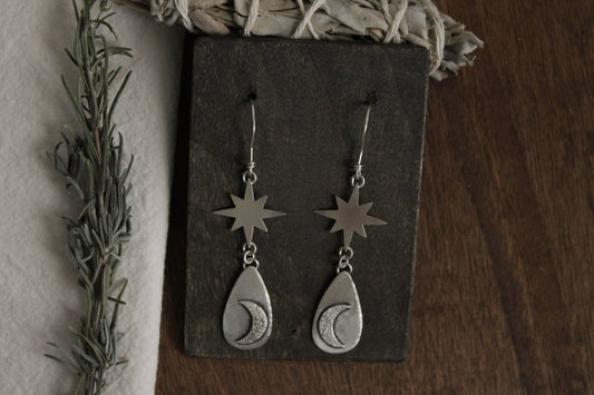Handcrafted sterling silver earrings, celestial charm jewelry, sustainable sterling silver earrings, recycled silver jewelry, artisan-crafted earrings, unique silver statement earrings, celestial-themed earrings, sustainable fashion accessories, moon-inspired earrings, eco-friendly jewelry, handmade statement earrings, ethical silver jewelry, silver drop earrings, moon magic jewelry, celestial silver earrings, handmade in the USA, silver dangle earrings, silver jewelry for women, timeless silver earrings