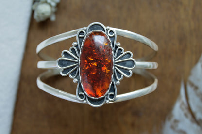 Handcrafted Golden Hour Statement Cuff featuring glowing Baltic amber in vintage-inspired recycled sterling silver setting, sustainable statement jewelry with intricate lace details and comfortable triple split band design