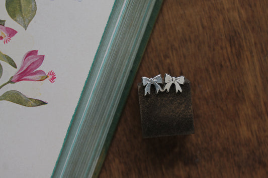 Dainty sterling silver bow stud earrings, handmade from recycled materials, perfect for Valentine’s Day or everyday feminine style.