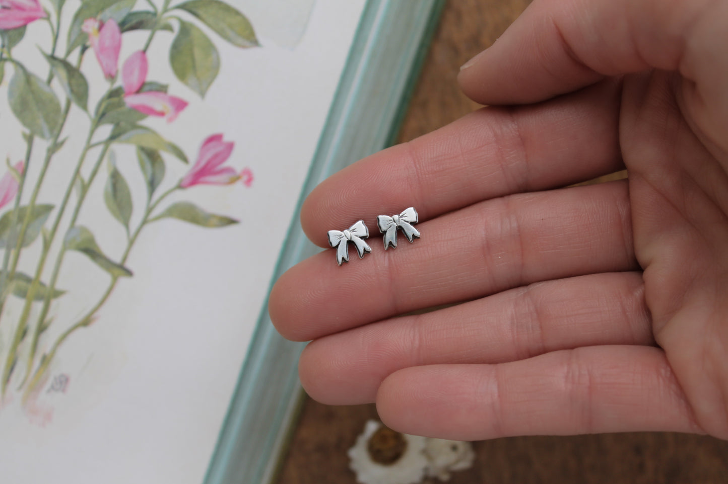 Sweet ribbon bow motif stud earrings crafted from responsibly sourced sterling silver, ideal for eco-conscious jewelry lovers.