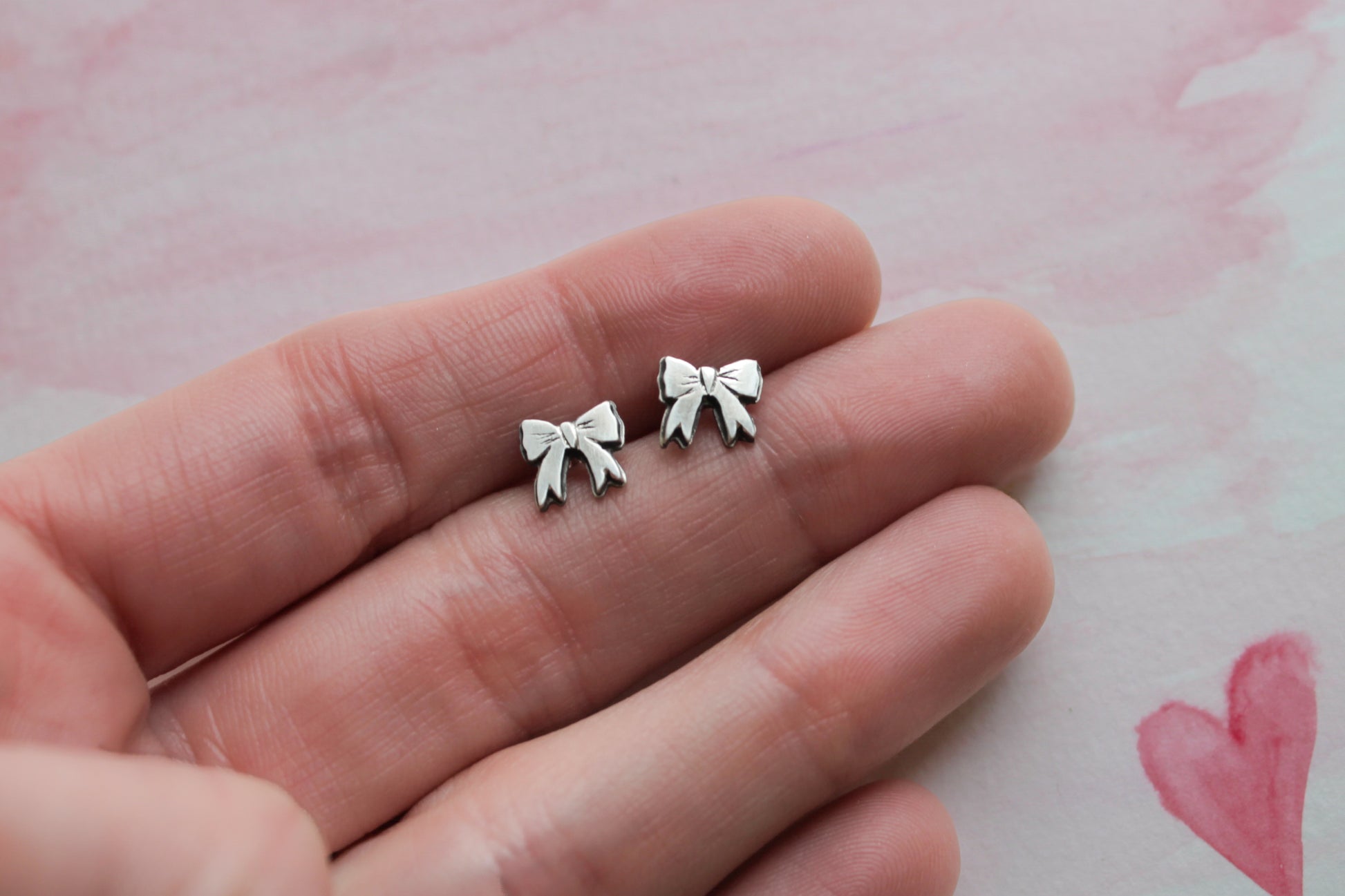 Feminine sterling silver bow earrings, perfect for adding a dainty touch to everyday outfits or gifting.