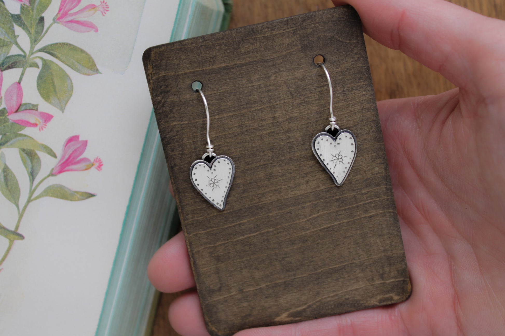 Sustainable silver dangle earrings with romantic hand-stamped heart details, polished to a satin finish for timeless charm.