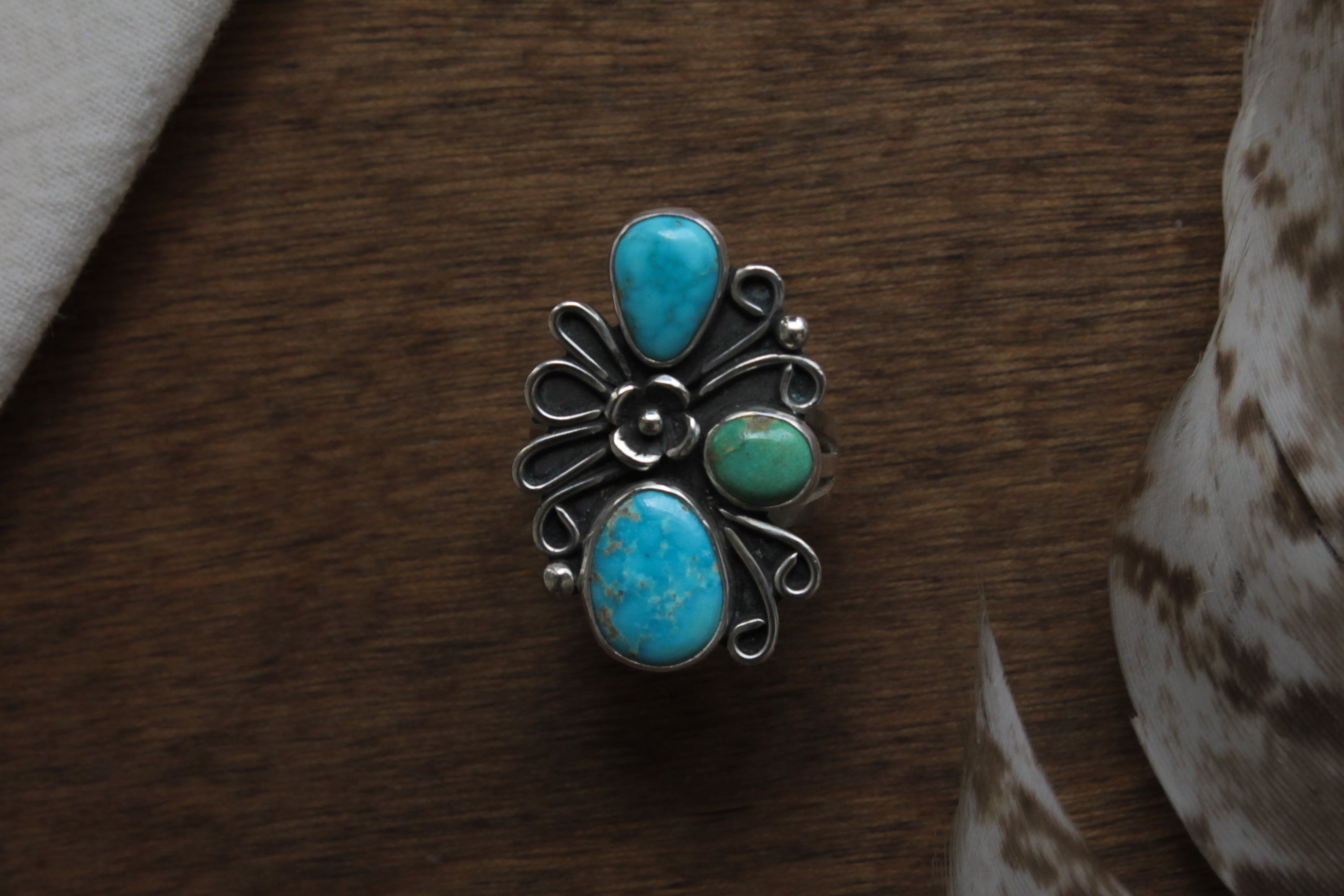 Vintage-inspired turquoise cluster ring featuring genuine blue and green turquoise stones with handcrafted silver floral and swirl details