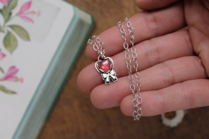 Valentine's-inspired rose quartz pendant necklace with oxidized sterling silver chain and a sweet handcrafted bow detail.