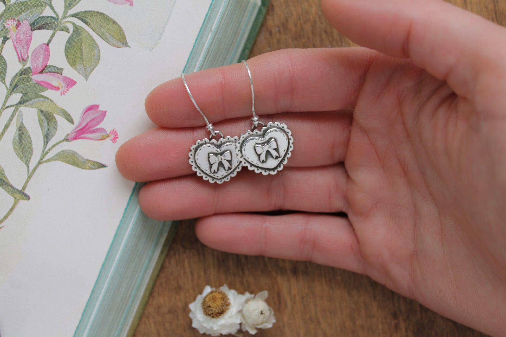 Sterling silver Valentine’s earrings featuring delicate heart shapes, French hooks, and intricate handcrafted details.