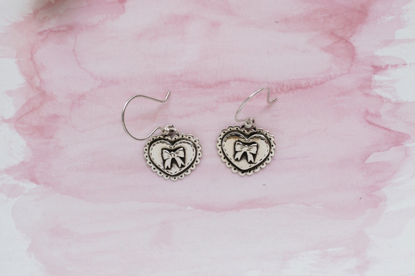 Handmade statement earrings with heart-shaped designs, crafted from recycled sterling silver with hand-stamped details.