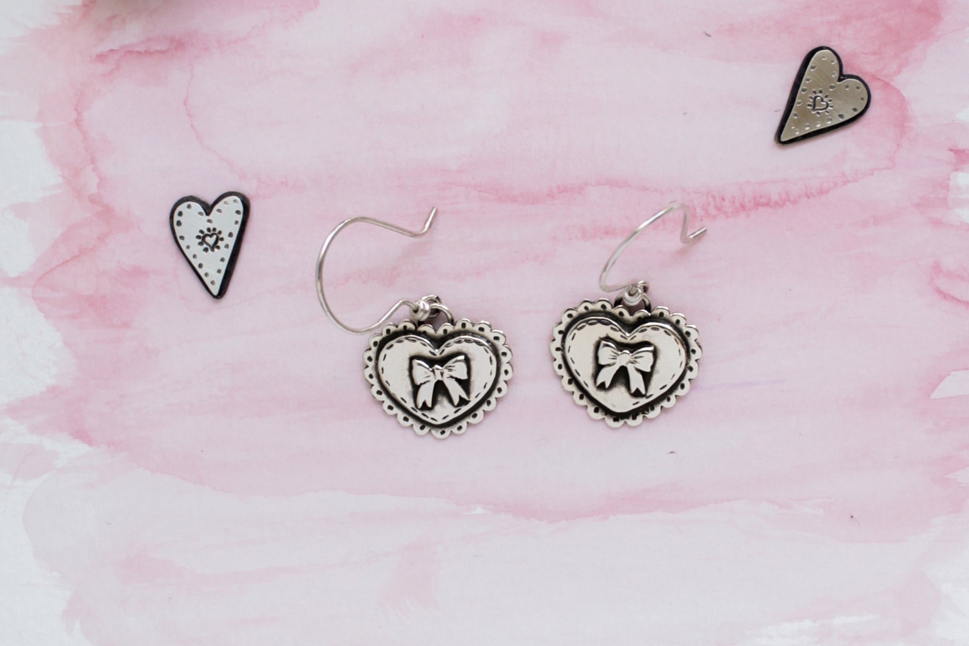 Statement earrings with whimsical heart motifs, lovingly handmade with recycled sterling silver and polished to a soft glow.