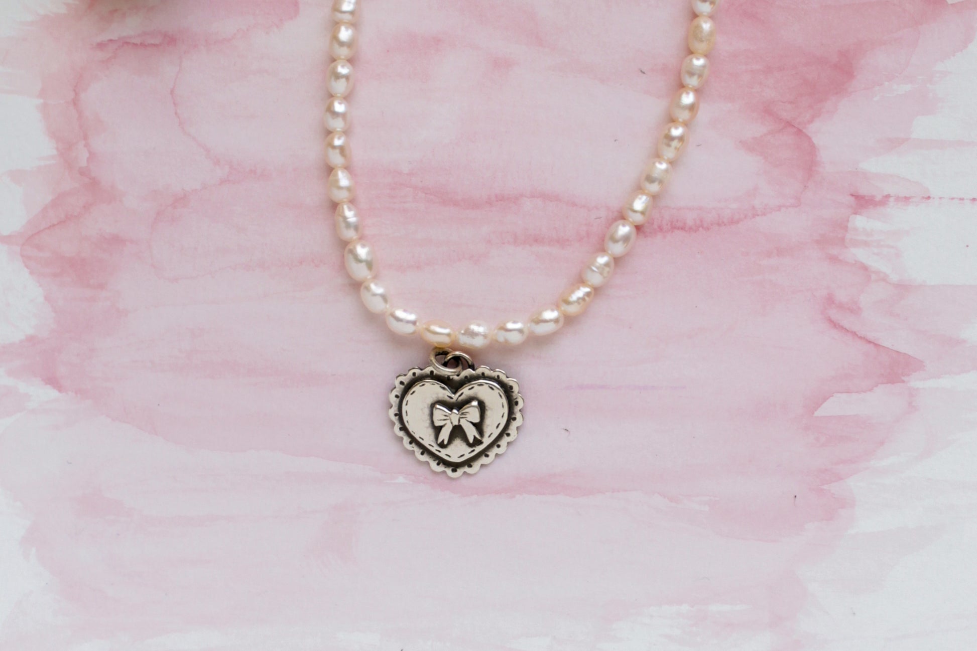 Pearl necklace with a handmade silver heart pendant, celebrating love and thoughtful craftsmanship.