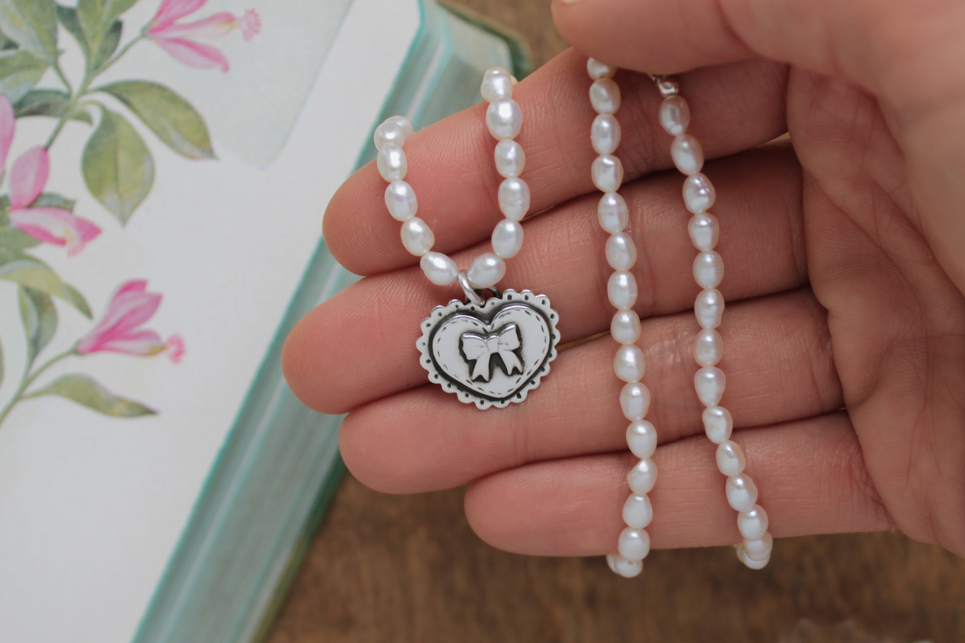 Dainty pearl necklace with a hand-cut silver heart charm, ideal for romantic occasions and heirloom-quality jewelry.