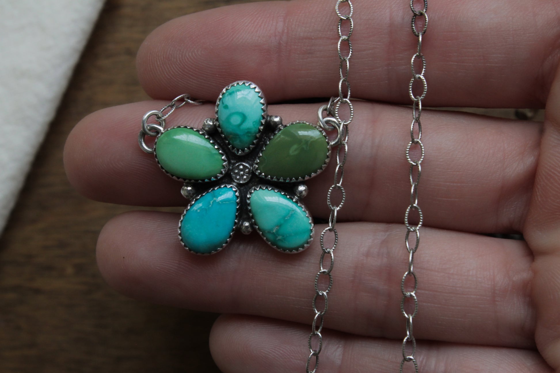 Close-up of Wildflower Turquoise Necklace, showcasing teardrop-shaped turquoise gemstones arranged in a floral-inspired cluster on an oxidized sterling silver chain.