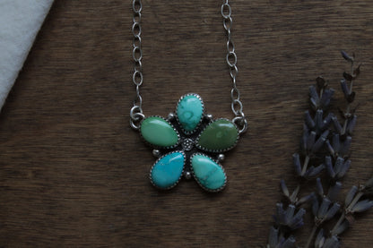 Wildflower Turquoise Necklace with genuine Emerald Valley Turquoise gemstones, handcrafted in responsibly recycled sterling silver. Vibrant teardrop turquoise stones form a unique wildflower cluster pendant on an 18-inch oxidized sterling silver chain, polished to a satin finish. Sustainable, one-of-a-kind artisan statement necklace.